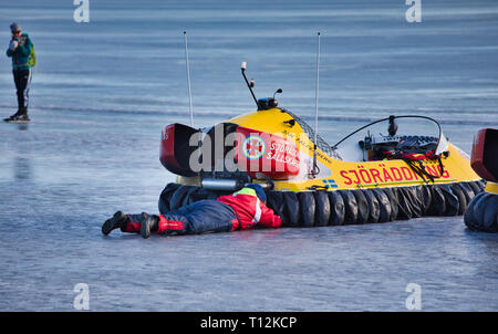 Crew Mitglied freiwillige Arbeiten auf einer offenen hovercraft der Schwedischen Sea Rescue Gesellschaft auf dem Eis des Sees Malaren, Sigtuna, Schweden, Skandinavien Stockfoto