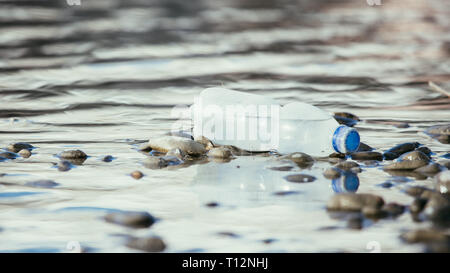 Plastikflasche liegt auf dem steinigen Strand, Umweltverschmutzung Stockfoto