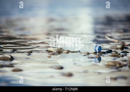 Plastikflasche liegt auf dem steinigen Strand, Umweltverschmutzung Stockfoto