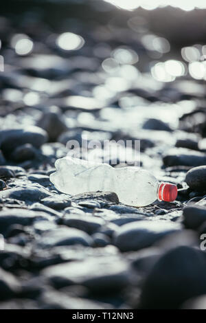 Plastikflasche liegt auf dem steinigen Strand, Umweltverschmutzung Stockfoto