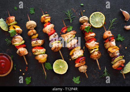 Mit gegrilltem Gemüse und hähnchenspieße mit Paprika, Zucchini, Zwiebel und Pilze auf schwarzen Hintergrund, Ansicht von oben, kopieren. Fleisch und Gemüse Stockfoto