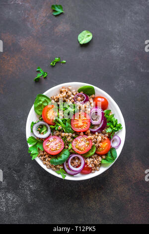 Buchweizen Salat mit Gemüse und Grüns auf schwarzen Hintergrund, kopieren. Heathy sauber vegane Rohkost, frischem Salat mit Buchweizen. Stockfoto