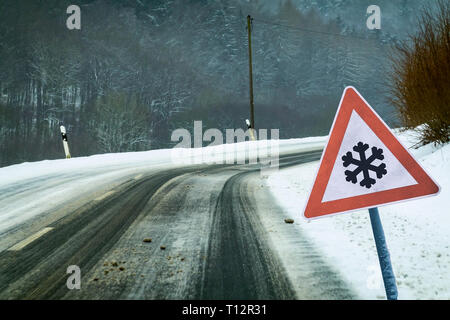 Snowy kurvigen Strasse mit verkehrsschild Snowy kurvigen Strasse mit Verkehrsschild Stockfoto