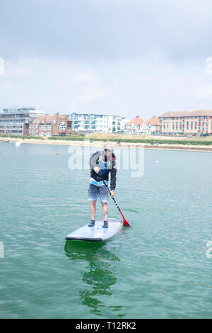 Ein Mann stand up Paddle Boarder bei Hove Lagune Stockfoto