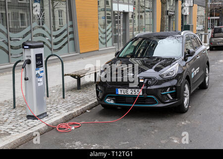 Ein Kia Niro Plug-in Hybridauto zu einem elektrischen Ladestation an der Seite einer Straße in der Stadt Trondheim in Norwegen. Stockfoto