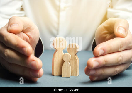 Insurance Agent hält die Hände in der Nähe der Familie. Das Konzept der Versicherung von Familie und Eigentum. Familie Pflege und helfende Hand Konzept. Gesundheit insura Stockfoto