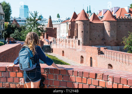 Warschau, Polen berühmten barbican Altstadt historische Hauptstadt während der sonnigen Sommertag und red orange brick wall Festung Architektur mit junge Frau Stockfoto