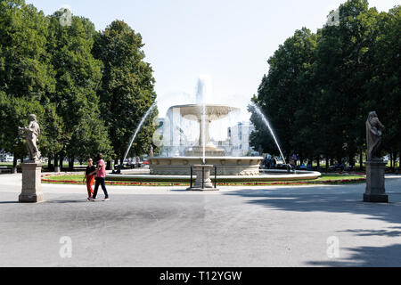 Warschau, Polen - 23. August 2018: Touristen durch Wasser Fountain Square im Sommer Saxon Gardens Park mit Spritzen spritzen Skulpturen Stockfoto