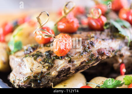 Lammkeule Braten im Ofen mit Tomaten, Kartoffeln Grüns und Rosmarin Stockfoto