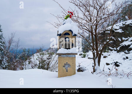 Eine verschneite Kandylakia, ein Heiligtum, wo ein Autounfall in Griechenland aufgetreten. Sie sind im ganzen Land gefunden, von einer Familie platziert. Stockfoto