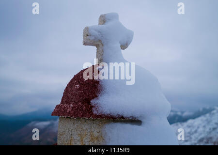 Eine verschneite Kreuz auf einem Kandylakia, ein Heiligtum, wo ein Autounfall in Griechenland aufgetreten. Sie sind im ganzen Land, gefunden. Stockfoto