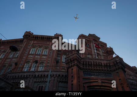 Ein Flugzeug fliegt über eine alte Britische Schule in Istanbul, Türkei.