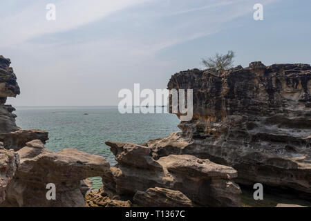 Erodiert vulkanischen Felsen am Meeresufer mit Blick auf das Meer und den Horizont im Hintergrund, Bild von der Insel Phu Quoc in Vietnam. Stockfoto