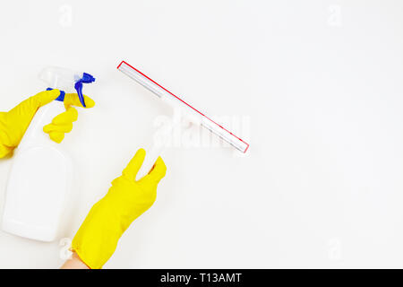 Frau Hände mit gelben Gummihandschuhe holding Fenster Glas Reinigung Werkzeug- und Spray Flasche mit Reinigungsmittel auf weißem Hintergrund Stockfoto
