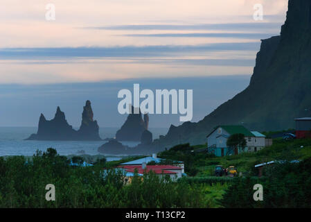 Häuser und Basalt sea Stacks im Ozean, Vik, Island Stockfoto