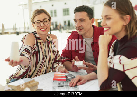 Lächelnde Menschen auf der Suche nach neuen Möbeln in Zukunft Innenraum Stockfoto