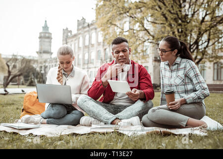 Konzentriert brunette männliche Person an seinem Gadget starrte Stockfoto