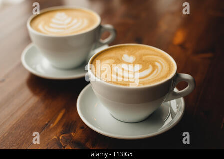 Zwei Tassen Cappuccino auf dem Holztisch. Stockfoto