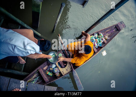 Amphawa, Thailand. Oktober 25, 2015. Mönch empfangen morgen Alms in Amphawa aus einem Anbeter. Stockfoto