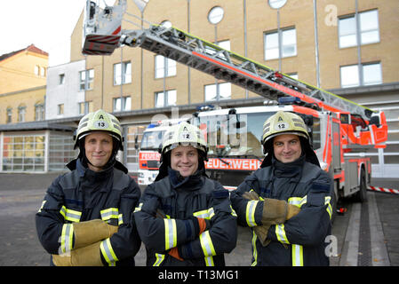 Portrait von drei lächelnd Feuerwehrmänner stehen auf Hof vor Fire Engine Stockfoto