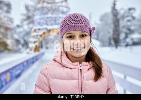 Porträt eines Mädchens, das Tragen von Wooly hat, Spaß Eislaufen auf der Eisbahn Stockfoto