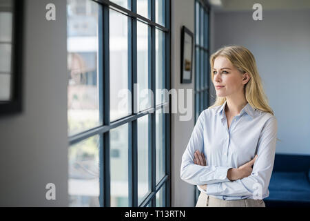 Zuversichtlich Geschäftsfrau im Büro Blick aus Fenster Stockfoto