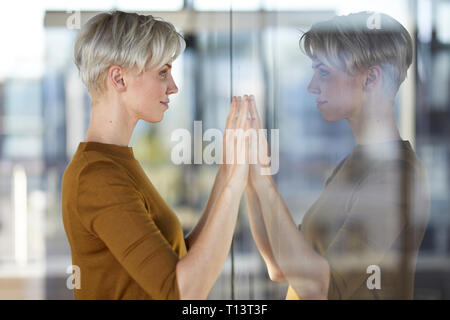 Frau im Fenster reflektiert Stockfoto