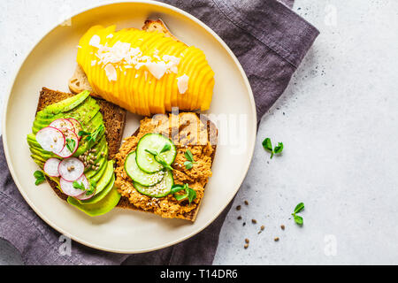 Veganen Sandwiches mit Mango, Avocado und Tofu Pastete auf einem weißen Teller. Auf Basis pflanzlicher Nahrung Konzept. Stockfoto