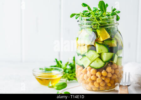 Grüner Salat mit Kichererbsen in einem Glas, weißer Hintergrund, kopieren. Detox, vegane Kost, Kost auf pflanzlicher Basis Konzept. Stockfoto