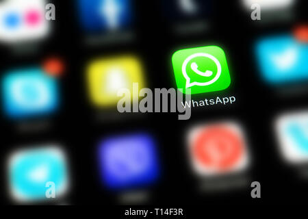Apple iPhone X mit Symbolen von social media WhatsApp und anderen verwischt Anwendung auf einem schwarzen Bildschirm. Social media Icons. Soziales Netzwerk Stockfoto