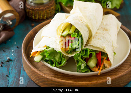 Gesundes Mittagessen Snack. Tortilla Wraps mit gegrilltem Huhn und frischem Gemüse auf der blauen Tabelle. Chicken Tortilla, Mexikanischen Straße fast food. Stockfoto