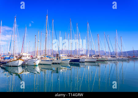 Marina mit verankert Fischerboote, Sandstrand und der schönen Stadt Agios Nikolaos im Hintergrund, Kreta, Griechenland. Stockfoto