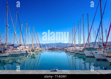 Marina mit verankert Fischerboote, Sandstrand und der schönen Stadt Agios Nikolaos im Hintergrund, Kreta, Griechenland. Stockfoto