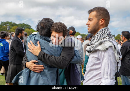 Christchurch, Canterbury, Neuseeland, 22. März 2019: Muslimische Männer einander im Gebet service Grüße in den Hagley Park, der eine Woche nach der Moschee schießen Stockfoto