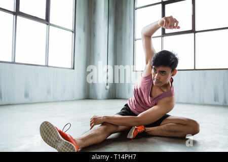 Asiatische junge Mann tun, Abdominal- dehnen vor dem Training Stockfoto