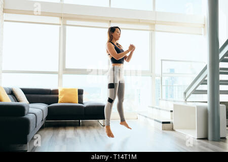 Erwachsene Frau Training Beine tun Hocke und Springen Stockfoto