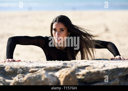 Portrait von sportlichen Frau Ausübung auf stein Wand Stockfoto