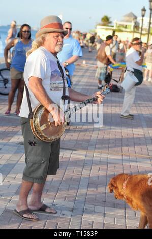Männliche Musiker Street Performer spielen Banjo für Massen von Touristen am Mallory Square in Key West, Florida Keys, Florida, USA Stockfoto