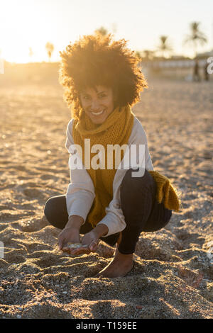 Frau sammeln Muscheln am Strand Stockfoto