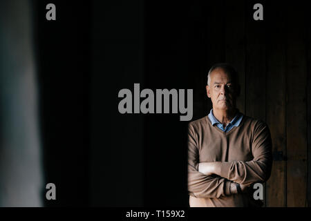 Porträt von Ernst senior Geschäftsmann vor der hölzernen Wand Stockfoto