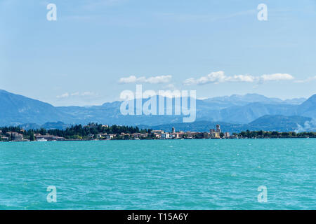 Panoramablick von Sirmione vom Gardasee mit Bergen im Hintergrund. Sirmione ist mittelalterliche Stadt Sirmium entfernt auf der Halbinsel des Gardasees, Stockfoto