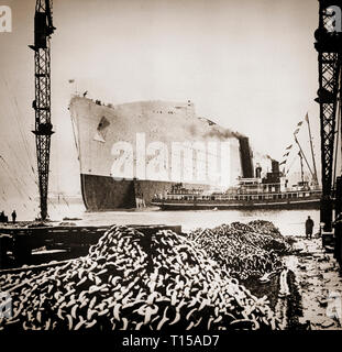 Begann im Dezember 1930 auf den Fluss Clyde von der John Brown & Company in Clydebank Werft in Schottland, der neue Liner von Queen Mary als RMS Queen Mary im September 1934 ins Leben gerufen wurde. Auf dem Weg nach Unten der Helling, Queen Mary wurde von achtzehn Schleppketten, die Fortschritte der Laufbuchse in den Fluss Clyde, dessen Teil überprüft verlangsamt ausgeweitet worden seien die Einführung gerecht zu werden. Stockfoto