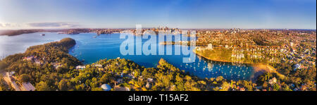 Erhöhte Luftaufnahme über den Hafen von Sydney aus über Mosman und Lower North shore Vororten in Richtung Innenstadt Wahrzeichen und Waterfront. Stockfoto