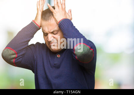 Mittleres Alter arabischer Mann über isolierte Hintergrund Kopfschmerzen leiden, verzweifelte und betonte, weil Schmerz und Migräne. Hände auf den Kopf. Stockfoto