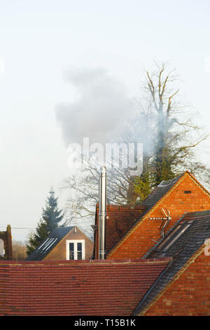 Buckingham, Großbritannien - 11 December 2018. Eine heimische Biomasse Rauchrohr Rauch Dämpfe in die Umgebung Stockfoto