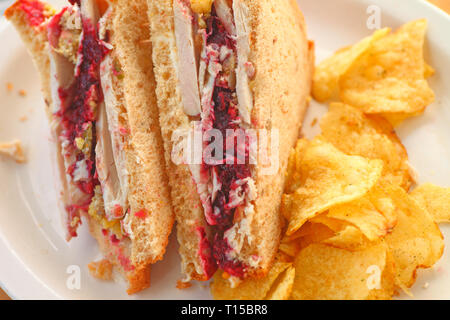 Sandwich von Thanksgiving übrig gebliebene Türkei, Preiselbeersoße und Füllung mit Füllung - gewürzte Kartoffelchips Stockfoto