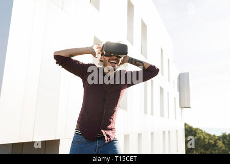 Mann auf einer Dachterrasse, Spiele mit VR-Brille Stockfoto