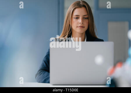 Portrait einer jungen Geschäftsfrau, Arbeiten im Büro, mit Laptop Stockfoto