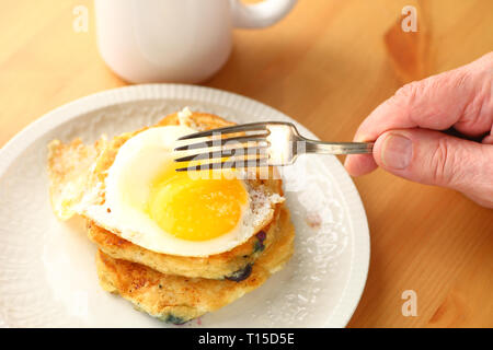 Blaubeerpfannkuchen mit Spiegelei mit hand Mann mit Gabel gekrönt Stockfoto