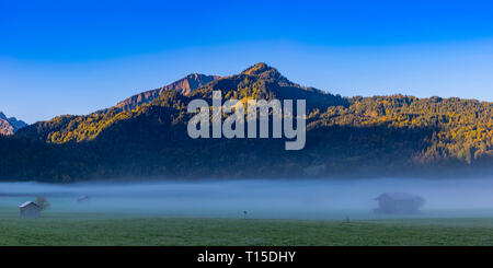 Deutschland, Bayern, Oberallgaeu, Loretto Wiesen in der Nähe von Oberstdorf mit dem morgendlichen Nebel und Berge im Hintergrund Stockfoto